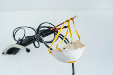 The construction mask dangles from a piece of wire sticking out of the wall. Respiratory protection for interior decoration and painting of premises. Close-up