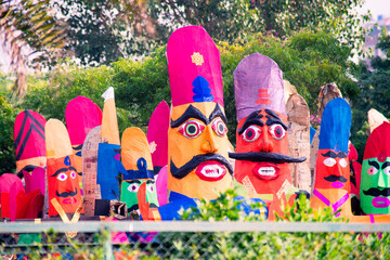 roadside streetside shot of huge paper mache effigies puppets of demon ravana being built in...