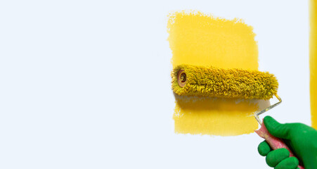 Male hand painting wall with paint roller