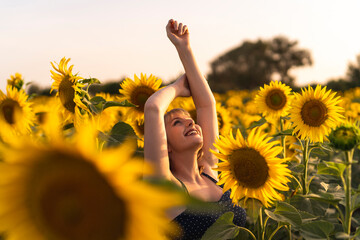 Chica joven guapa sonriendo y posando en un campo de girasoles