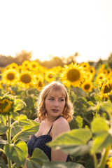 Chica joven guapa sonriendo y posando en un campo de girasoles