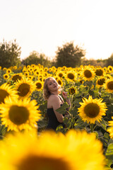 Fototapeta na wymiar Chica joven guapa sonriendo y posando en un campo de girasoles