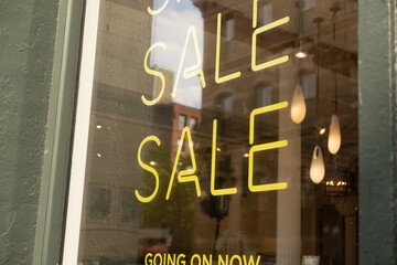 Obraz premium Yellow neon Sale sign on store window display