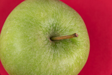 Green apple on the red background