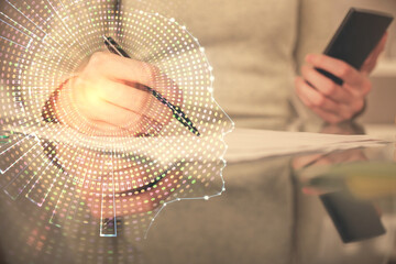 Double exposure of brain sketch hologram and woman holding and using a mobile device.