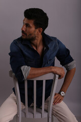 Man in blue shirt sitting on the chair