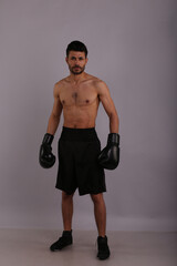 Fototapeta na wymiar Boxer in boxing gloves on gray background