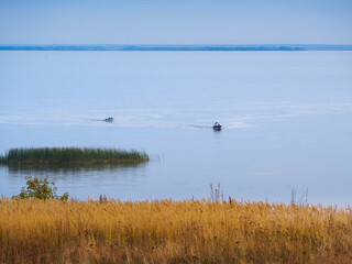 Two boats sails to the shore, evening at the mouth of the Kama River, which flows into the Volga River, Republic of Tatarstan, Russia.
