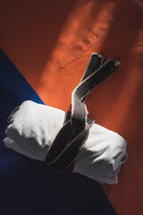 White kimono tied with a black belt on an orange tatami in a martial arts hall. Place for text.