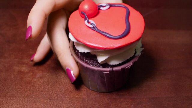 Advent of cupcake with red decoration in shot. Unusual decor with sex toys