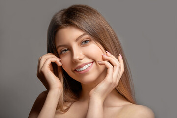 Young beautiful woman smiling on gray studio background