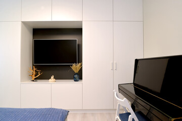 TV in the niche of cabinet furniture and piano. Living room