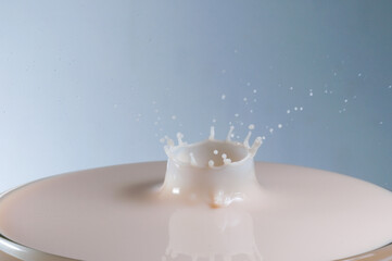 Efeito de gota caindo em copo cheio de leite congelando  um momento e formando uma coroa. 