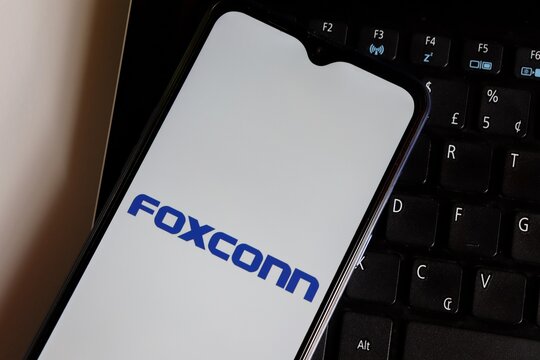 Brazil - October 20, 2020. Foxconn logo on smartphone screen on top of laptop. Foxconn Technology Group.