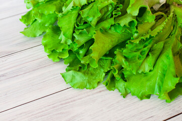 fresh green lettuce leaves on a light wooden background. High quality photo