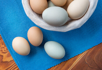 Fresh Chicken and duck eggs collect from farm products natural on a blue cloth background - healthy eating concep. Top View