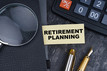 On the table is a calculator, a pen and a notebook with a bookmark on which it is written - Retirement planning