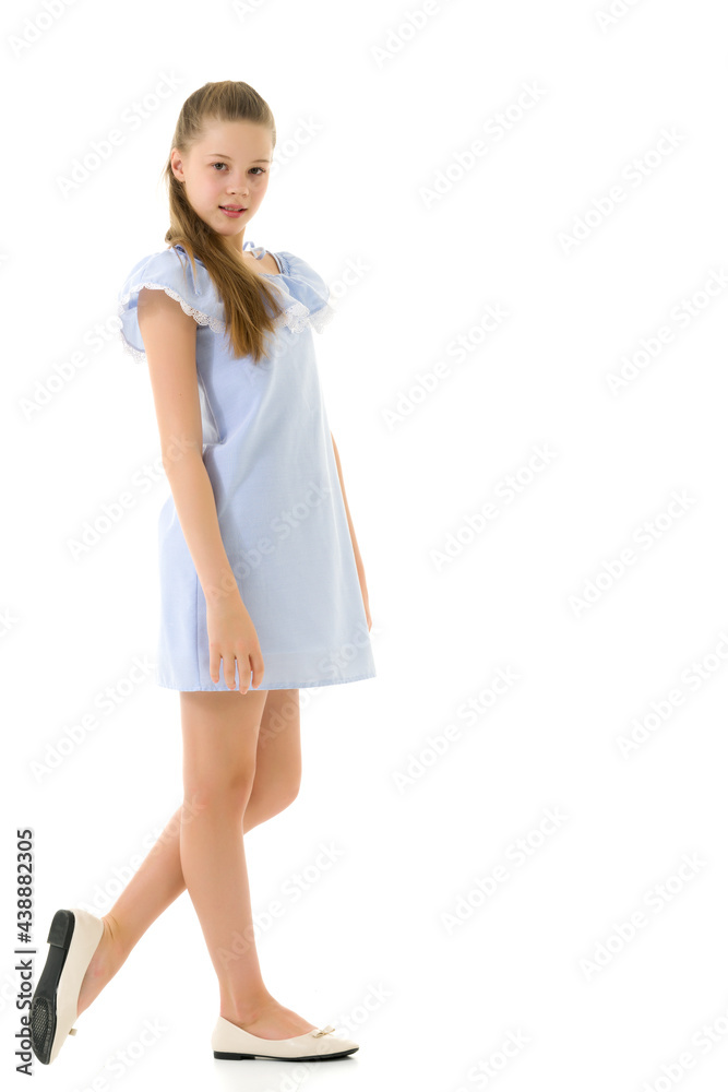 Wall mural Portrait of Teen Girl in Light Blue Dress Standing Half Turn