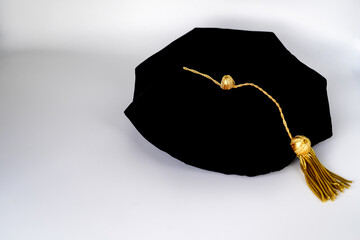 Isolated traditional black phd doctoral tam cap with gold tassel	
