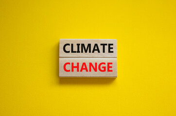 Climate change symbol. Wooden blocks with words 'Climate change' on beautiful yellow background. Business, ecological and climate change concept. Copy space.