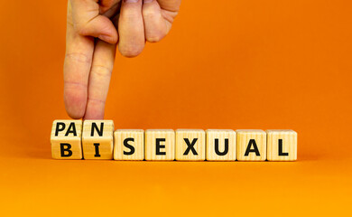 Pansexual or bisexual symbol. Doctor turns wooden cubes and changes the word 'bisexual' to 'pansexual'. Beautiful orange background, copy space. Social, pansexual or bisexual concept.