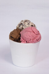 A small isopor container with ice cream of different flavors, on a white background.