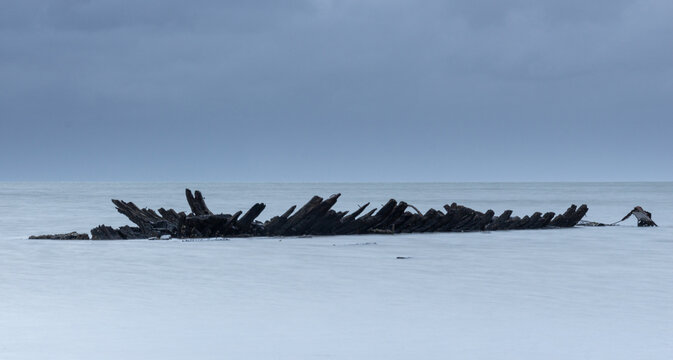 unheimliches Schiffswrack vor Sylt an einem wolkenverhangenen Morgen