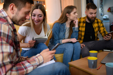 Students using a smartphnes while studying for their exam at home
