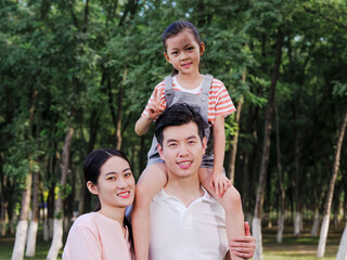 Naklejka premium Happy family of three playing in the park