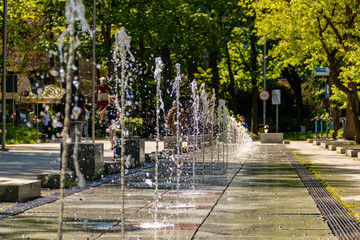 Sparkling water from fountain on touristic promenade in Kolobrzeg, Poland during spring evening at the baltic sea. - obrazy, fototapety, plakaty