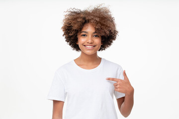 African student girl pointing with index finger at blank white t-shirt with empty space for your...