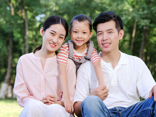 Happy family of three playing in the park