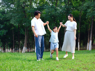 Naklejka na ściany i meble Happy family of three playing in the park