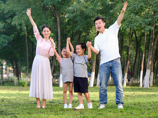 Fototapeta premium Happy family of four playing in the park