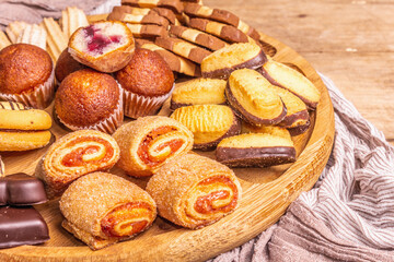 Assorted various cookies and muffins in wooden combination plate