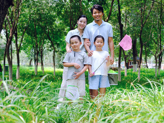 Fototapeta premium A happy family of four catching insects outdoors