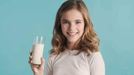 Portrait of pretty teenage girl holding glass of milk and sincer