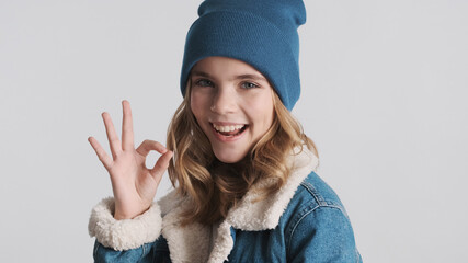 Beautiful smiling blond teenager girl dressed in hat and denim j
