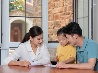 A Happy family of three using calculator