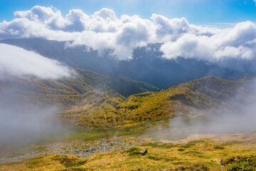 Clouds above the mountains at autumn day.