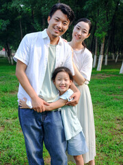 Happy family of three playing in the park