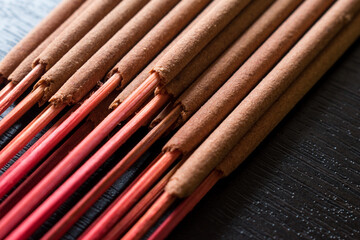 Some red incense branches on a black wooden table in a spa 