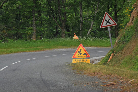 Panneau provisoire, chantier mobile, avertissant de la présence d'un tracteur fauchant la végétation le long d'une route.