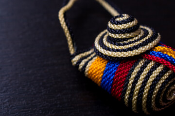 Close up of a Little striped colombian craft with the Colombia flag on a black wooden table 