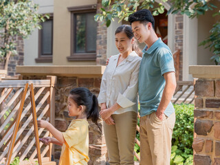 A Happy family of three painting outdoors