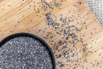 chia seeds on black bowl with wooden and jute background in Brazil