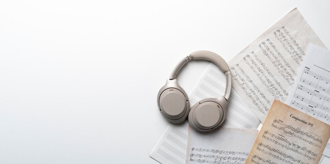 grey headphones on the music notes paper sheet