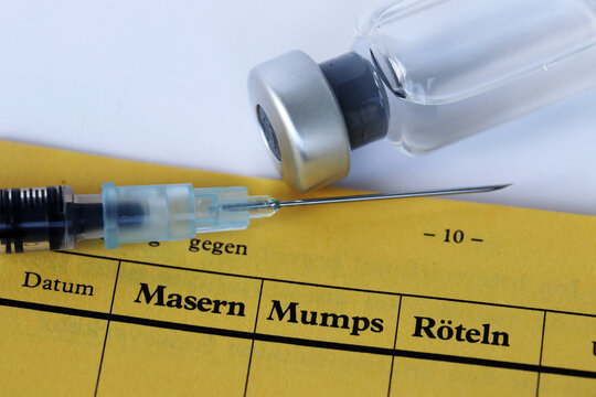 Impfung gegen Masern, Mumps und R&ouml;teln mit Impfpass, Spritze und Impfstoff