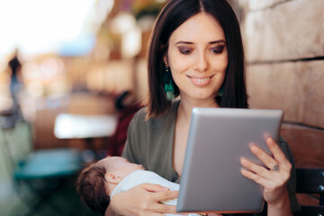 Happy Working Mom Holding Sleeping Baby and Pc Tablet in a Restaurant