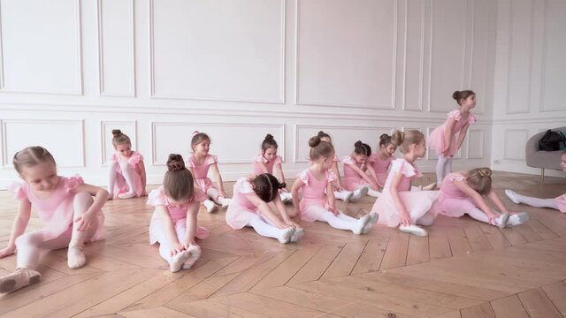 Girls dancers in ballet school learns to dance. Little Ballerinas in training in pink dancing suit. Children's ballet school. School of ballet.
